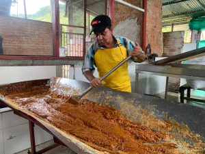 Persona revolviendo panela para que endurezca en una batea